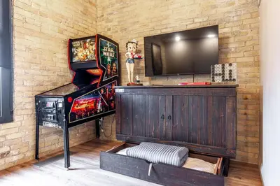 a room with a video game console and a television at Glyn Rhosyn Loft in Stratford