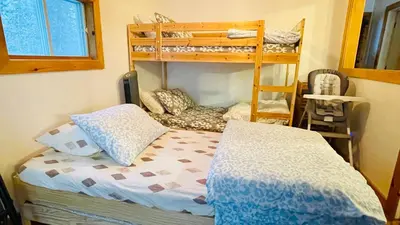 a bedroom with a bed and bunk beds in it at Charming Winter Cottage Retreat with Scenic Snow Views in Colborne