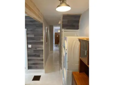 a kitchen with a refrigerator and a hallway at Lovely Leslieville, exploring nature in the city in Toronto