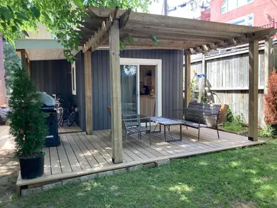 a pergola with a table and chairs on a deck at Lovely Leslieville, exploring nature in the city in Toronto