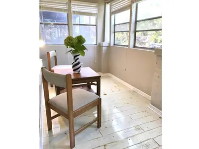 a dining room with a table and a vase with a plant at Lovely Leslieville, exploring nature in the city in Toronto