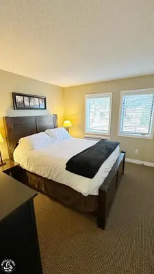 a bedroom with a large bed and two windows at Blue Mtn 1 Bedroom with Mountain View in Blue Mountains