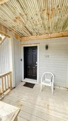a porch with a white chair and a black door at Blue Mtn 1 Bedroom with Mountain View in Blue Mountains