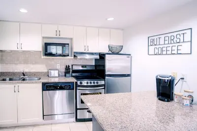 a kitchen with white cabinets and stainless steel appliances at Gorgeous Studio Condo in Blue Mountains Sleeps 4 in Blue Mountains