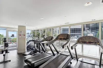 a gym with a row of treadmills and ellipticals at Toronto Views ~ Pool ~ BBQ ~ Harbourfront ~ WIFI in Toronto