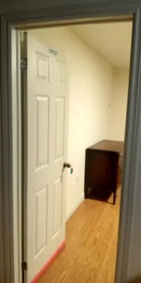 an empty room with a white door and a table at Cozy Town house in Toronto