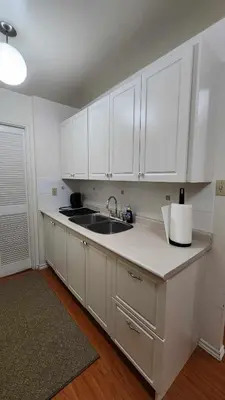 a kitchen with white cabinets and a sink at Cozy Town house in Toronto