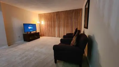 a living room with two chairs and a flat screen tv at Cozy Town house in Toronto