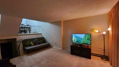 a living room with a couch and a flat screen tv at Cozy Town house in Toronto