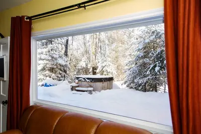 a window with a view of a snow covered yard at The Hidden Porch at Sir Sam's (hot tub & sauna) in Haliburton