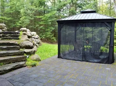 a gazebo with a table and chairs in it at The Hidden Porch at Sir Sam's (hot tub & sauna) in Haliburton
