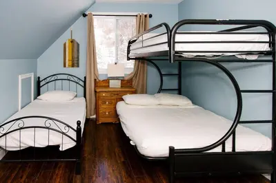 two bunk beds in a room with blue walls at The Hidden Porch at Sir Sam's (hot tub & sauna) in Haliburton