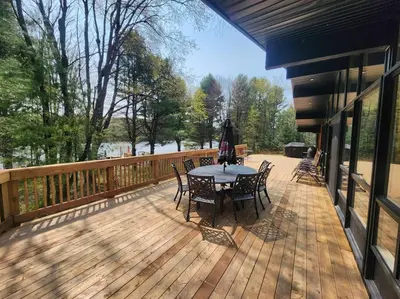 a patio with a table and chairs on a deck at Red Cedar Chalet on Brady Lake in Hindon Hill