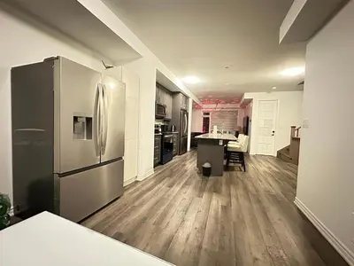 a kitchen with a refrigerator and a table in it at Keppel Circle Residence in Brampton