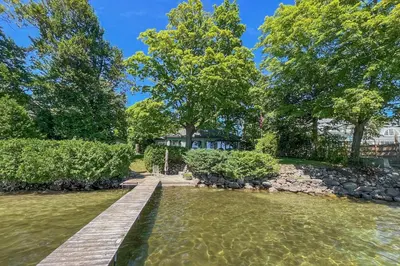 a pond in front of a house with trees at 2889 Purvis Street in Innisfil