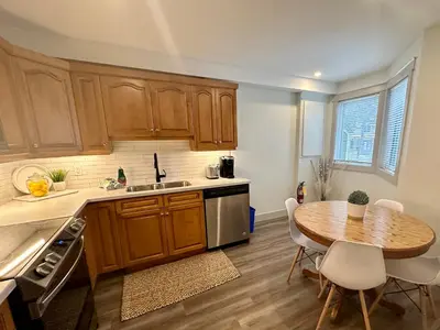 a kitchen with wooden cabinets and a wooden table at Beautiful tranquil centrally located condo in Collingwood