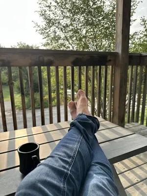 a person laying on a table with their feet on a deck at Beautiful tranquil centrally located condo in Collingwood