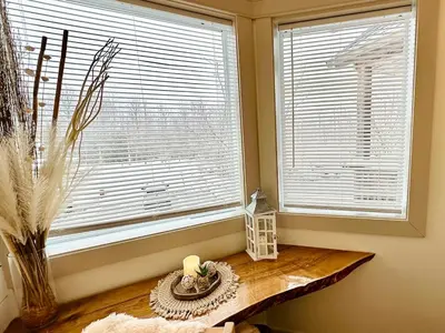 a room with a window and a table with a candle at Beautiful tranquil centrally located condo in Collingwood