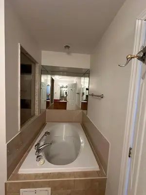 a large bath tub in a bathroom with a mirror at Spa Golf Bike in Collingwood