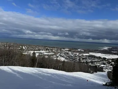 a snow covered hill with a city in the distance at Spa Golf Bike in Collingwood
