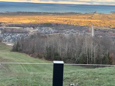 a view of a city from a hill with a black post at Greenview Retreat in Collingwood