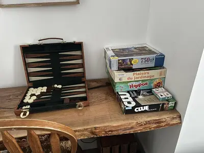 a wooden table with a stack of books and a boardgame at Pony Trail in Collingwood