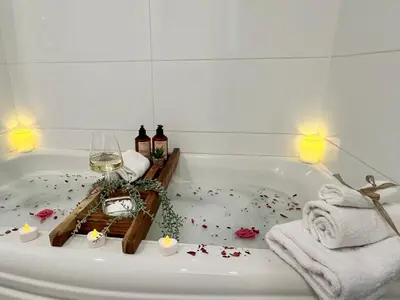 a bathroom with a bath tub with a glass of wine at Pony Trail in Collingwood