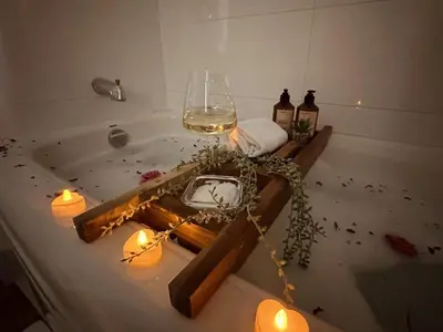 a bath tub with a glass of wine and candles at Pony Trail in Collingwood