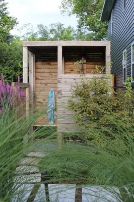 a wooden shed with a bench in a garden at Woodland Chase in Wellington