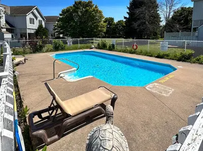 a swimming pool with a bench and a chair next to it at 19th Hole Hideaway in Collingwood