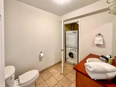 a bathroom with a toilet and a washing machine at 19th Hole Hideaway in Collingwood