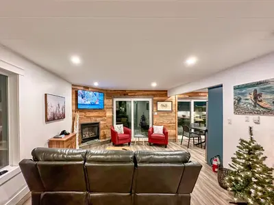 a living room with a leather couch and a christmas tree at The Fairway Flat in Collingwood