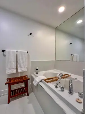 a bathroom with a tub and a sink and a mirror at The Fairway Flat in Collingwood