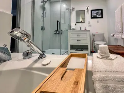 a bathroom with a shower and a sink with a lamp at The Fairway Flat in Collingwood