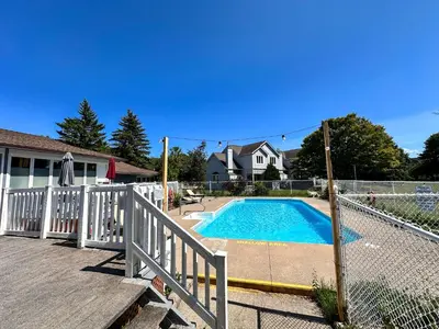 a swimming pool with a fence next to a house at The Fairway Flat in Collingwood