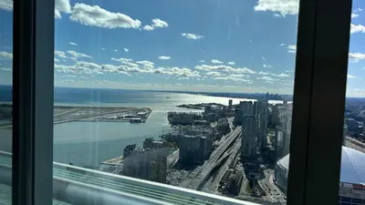 a view of the city from a window in a skyscraper at DOWNTOWN, LUXURY CONDO, CN TOWER, ROGERS CENTER, SCOCIA ARENA, UNOBSTRUCTED VIEW in Toronto