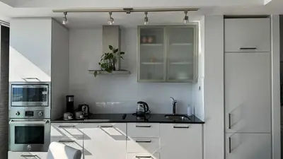 a white kitchen with a sink and a microwave at DOWNTOWN, LUXURY CONDO, CN TOWER, ROGERS CENTER, SCOCIA ARENA, UNOBSTRUCTED VIEW in Toronto