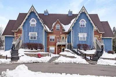a large blue house with snow in front of it at Cosy Chalet - 4 Season Family Oasis in Collingwood