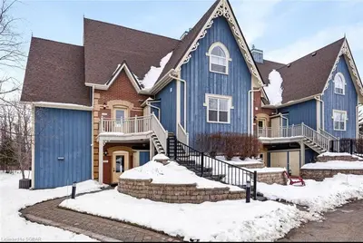 a large blue house with snow on the ground at Cosy Chalet - 4 Season Family Oasis in Collingwood