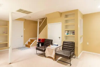 a room with two chairs and a table and stairs at Cozy basement apartment in Newmarket in Newmarket