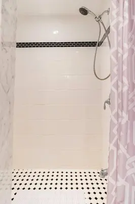 a bathroom with a shower with a black and white floor at Cozy basement apartment in Newmarket in Newmarket