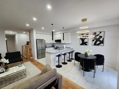 a living room and kitchen with a couch and a table at Exclusive Home in Niagara Falls in Thorold