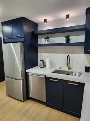 a kitchen with blue cabinets and a stainless steel refrigerator at Exclusive Home in Niagara Falls in Thorold