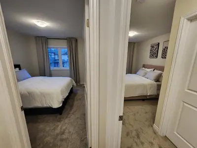 a bedroom with two beds and a window in it at Exclusive Home in Niagara Falls in Thorold