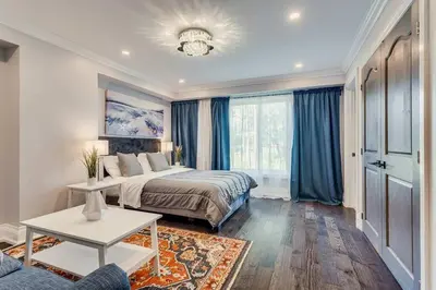 a bedroom with a bed with blue curtains and a table at Large Estate with Luxury Collection of Amenities in Schomberg