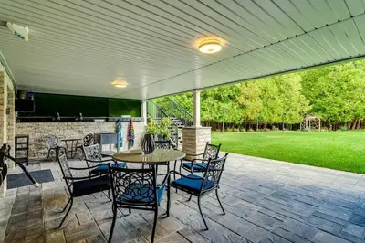 a patio with a table and chairs and a grill at Large Estate with Luxury Collection of Amenities in Schomberg