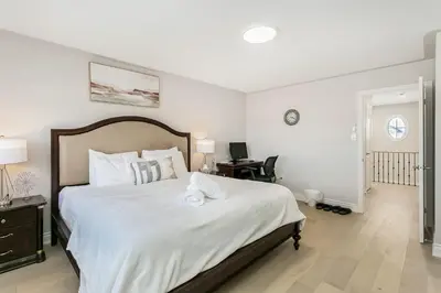 a bedroom with a large white bed with a desk at Pristine Pet & Smoke Free 4-Bedroom home near Canada's Wonderland in Vaughan