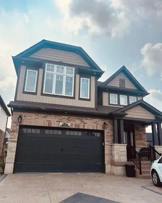 a large house with a garage door in front of it at Stunning House 4 bed 2.5 bath in Kitchener
