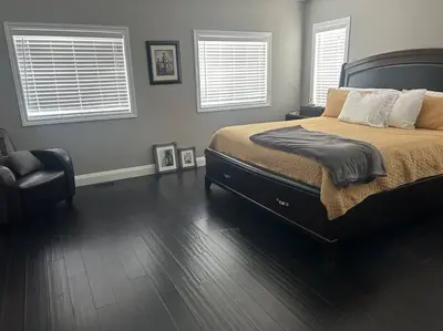 a bedroom with a large bed and two windows at Stunning House 4 bed 2.5 bath in Kitchener