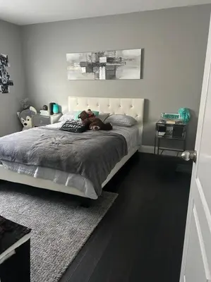 a teddy bear laying on a bed in a bedroom at Stunning House 4 bed 2.5 bath in Kitchener